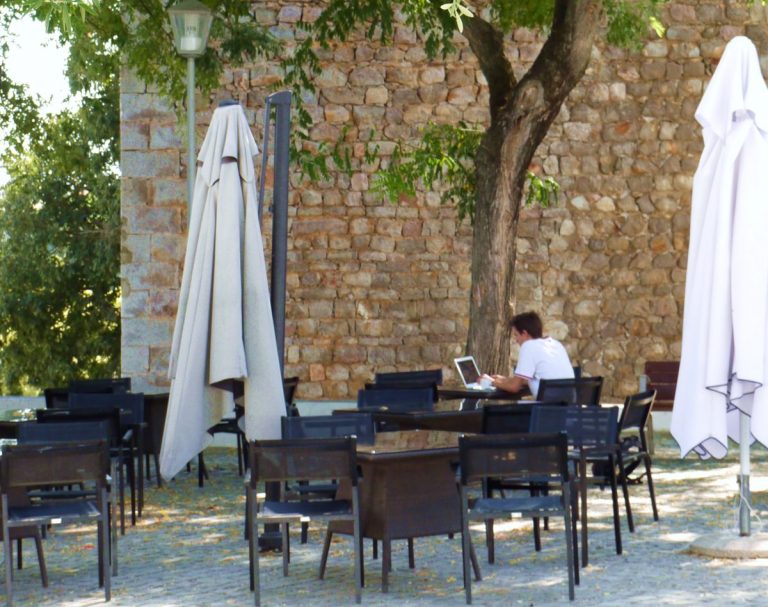 Tavira, Algarve, Portugal. Digital nomad at cafe in a fortress