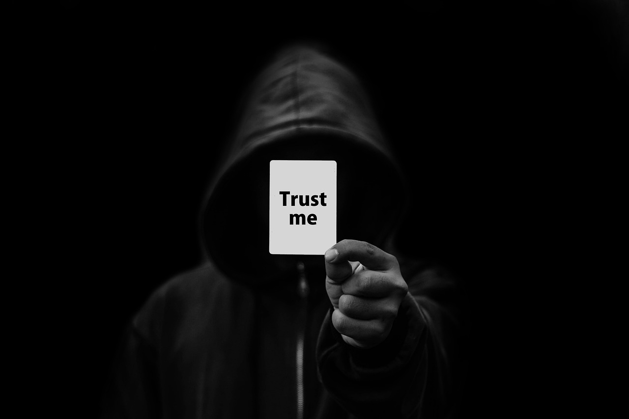 hooded man with trust sign in hand. photo gerd altmann